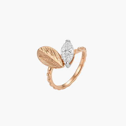 A rose gold ring featuring a textured leaf motif and a marquise-cut clear gemstone, shown on a clean white background.