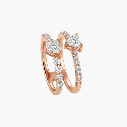 A pair of rose gold wedding bands with heart-shaped diamond settings and pavé accents, displayed on a clean white background.