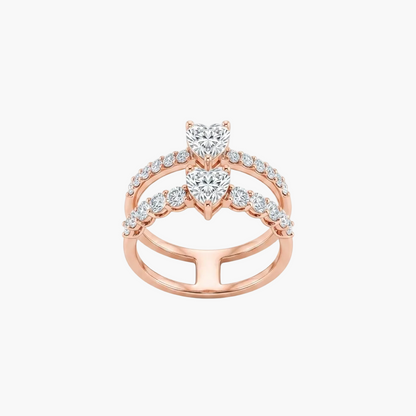 A rose gold double-band ring featuring two heart-shaped diamond center stones and rows of small round diamonds along the bands, set against a plain white background.