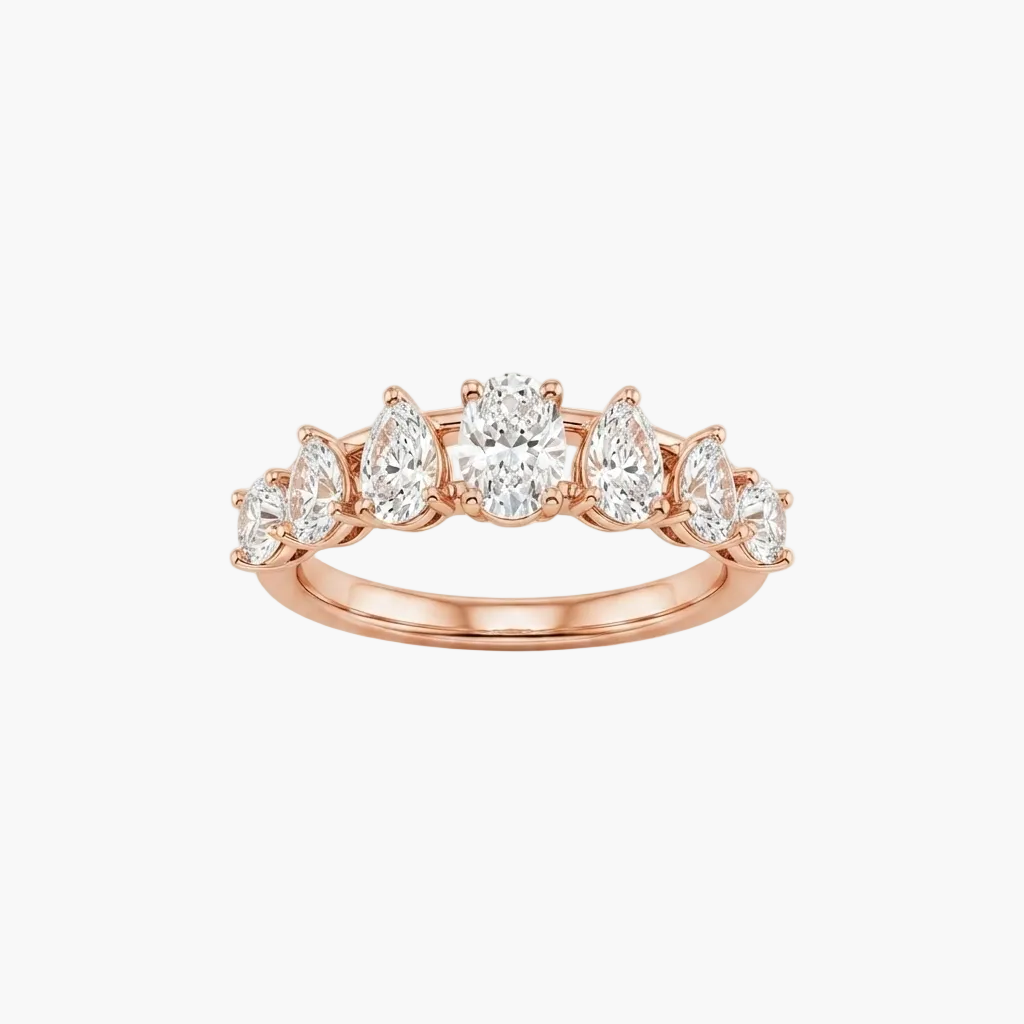 A rose gold diamond ring with a row of pear-cut and round diamonds, set against a clean white background.