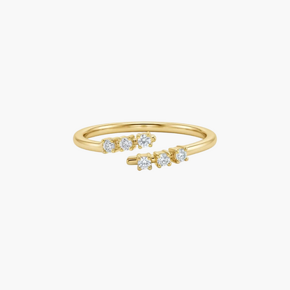 A delicate yellow gold ring with five small round-cut clear gemstones set along the band, photographed on a clean white background.