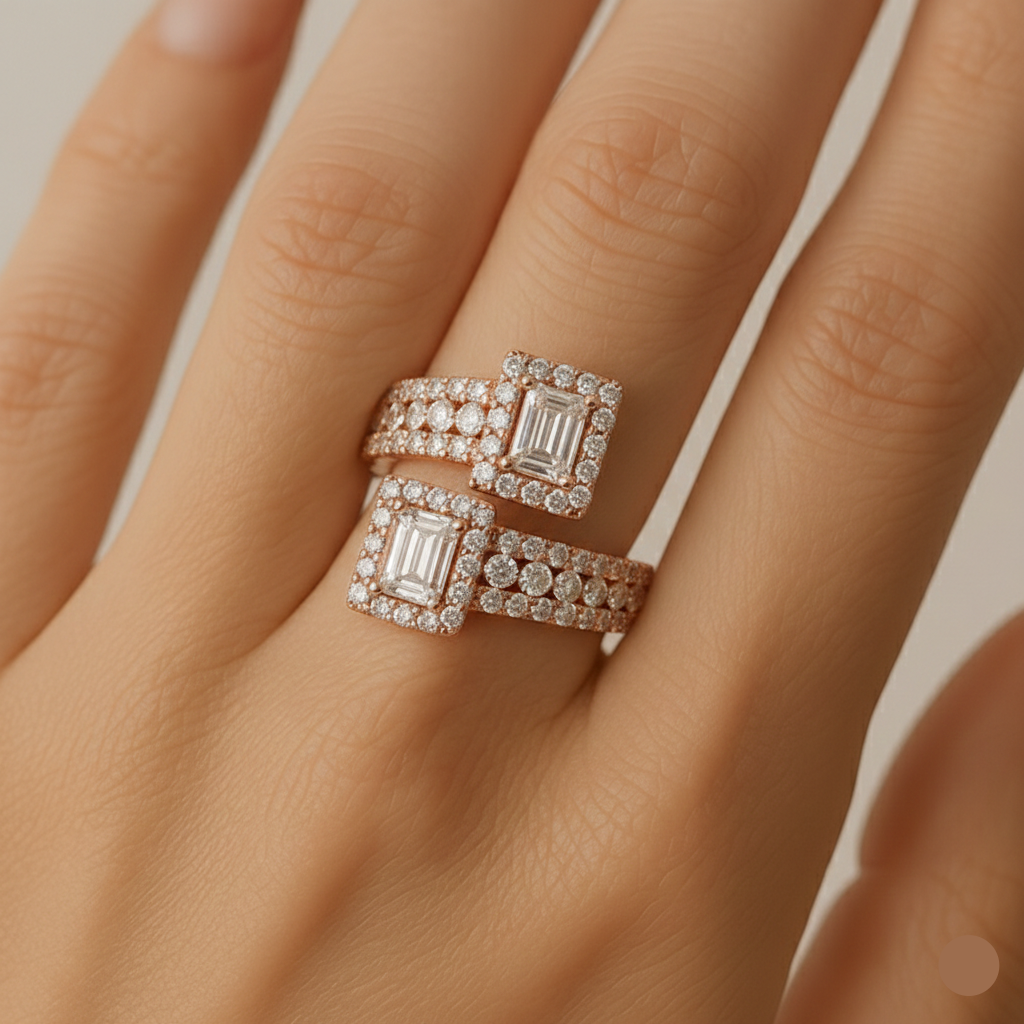 Rose gold ring with emerald-cut diamonds on a hand against a neutral background