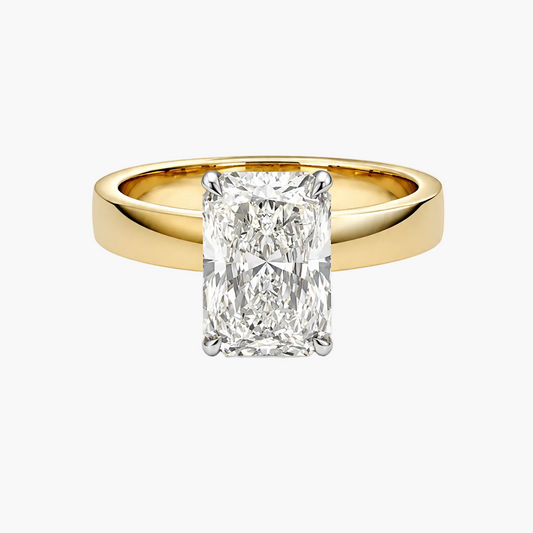A yellow gold ring with a large rectangular radiant-cut diamond center stone, shown on a clean white background.