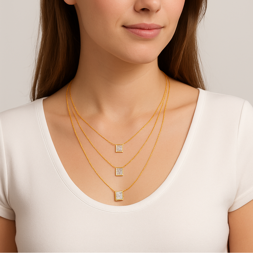 Woman wearing multiple gold necklaces with a plain background