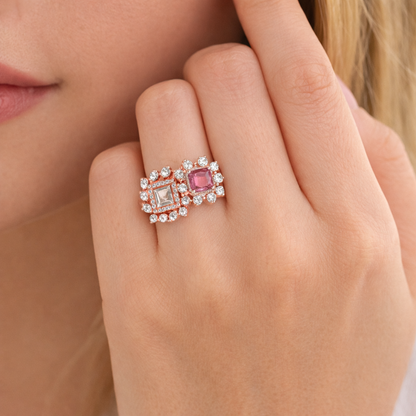 Close-up of a hand wearing a ring with a pink gemstone and diamond accents.