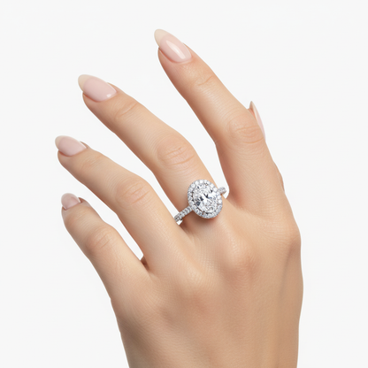Female model wearing delicate white gold oval diamond halo ring