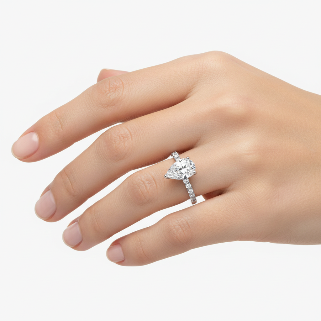 Female model wearing delicate white gold pear-shaped diamond ring