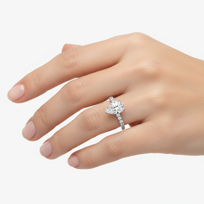 Female model wearing delicate white gold pear-shaped diamond ring