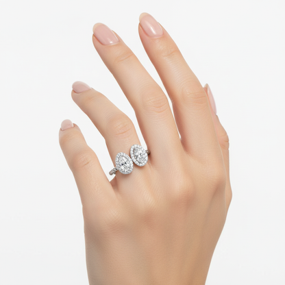 Female model wearing delicate white gold toi et moi pear-shaped diamond halo ring