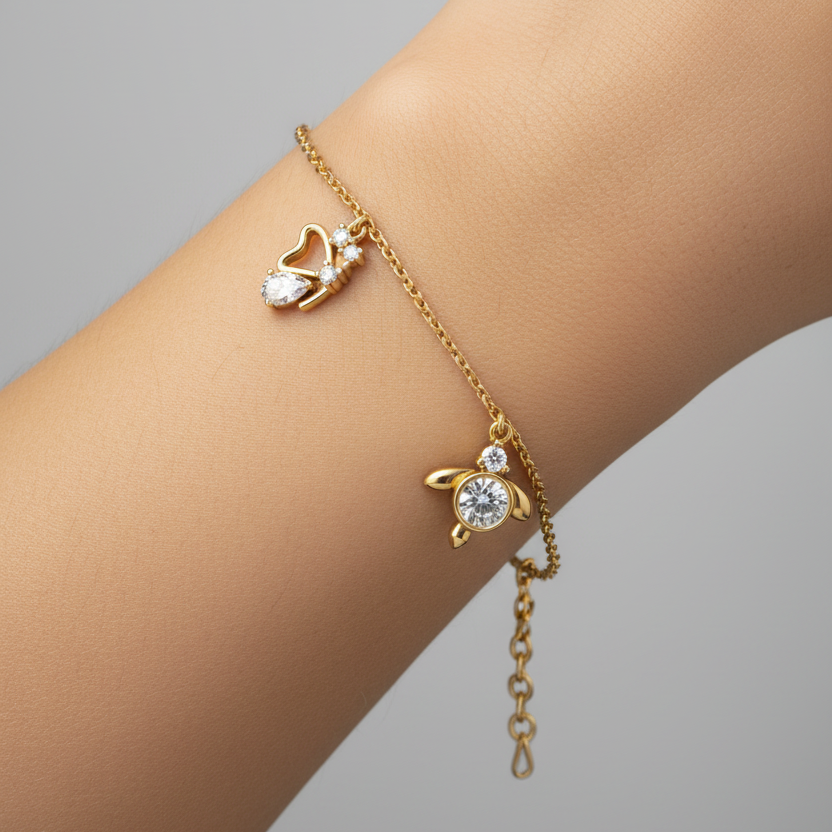 Female model wearing delicate yellow gold diamond charm bracelet with heart, bezel and butterfly diamond charms