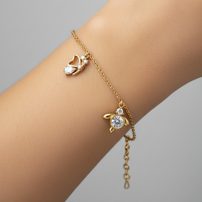 Female model wearing delicate yellow gold diamond charm bracelet with heart, bezel and butterfly diamond charms