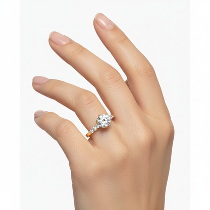 Female model wearing delicate yellow gold engagement ring with graduated diamonds