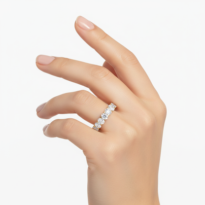 Female model wearing delicate yellow gold oval diamond eternity band