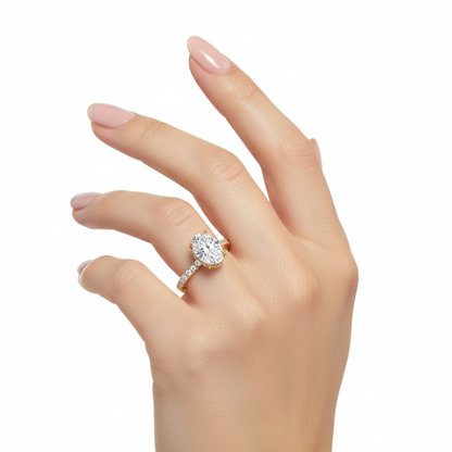 Female model wearing delicate yellow gold oval diamond ring with hidden halo