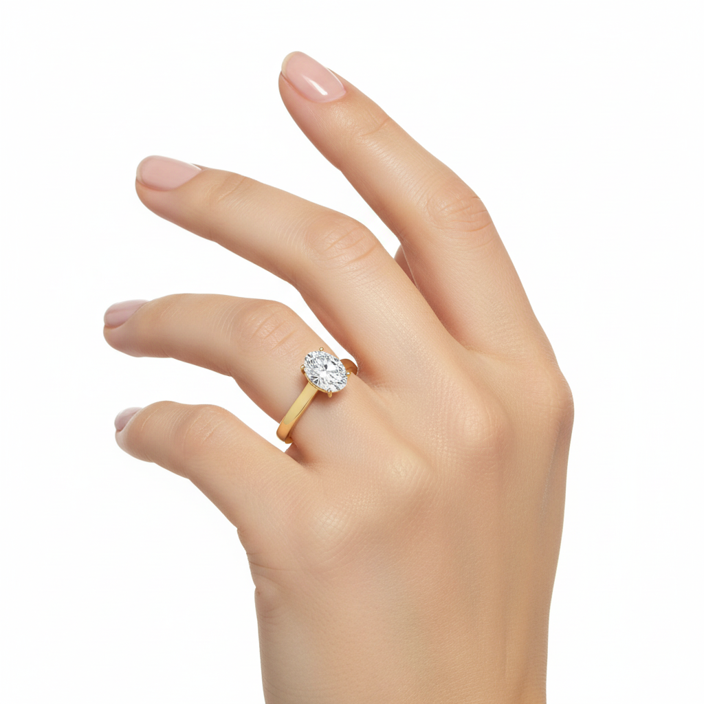 Female model wearing delicate yellow gold oval diamond solitaire ring