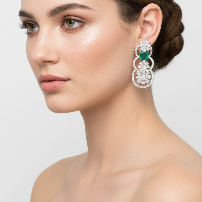 Female model wearing emerald and diamond drop earrings