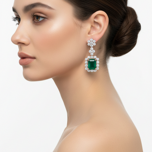 Female model wearing emerald and diamond earrings