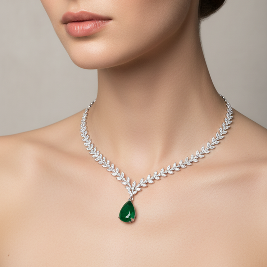 Female model wearing emerald and diamond laurel necklace
