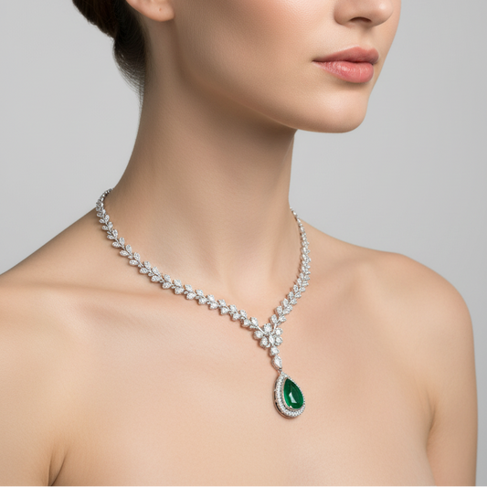 Female model wearing emerald and diamond leaf necklace