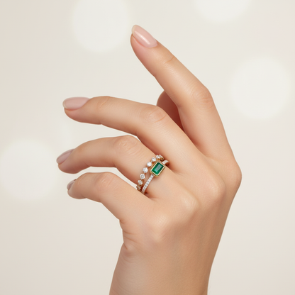 Female model wearing emerald and diamond stacked ring set