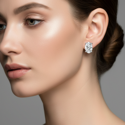 Female model wearing oval-cut diamond solitaire stud earrings in white gold