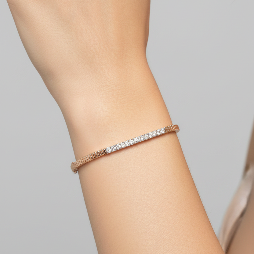 Female model wearing slim rose gold bracelet with central diamond bar section flanked by smooth polished rose gold rectangular links