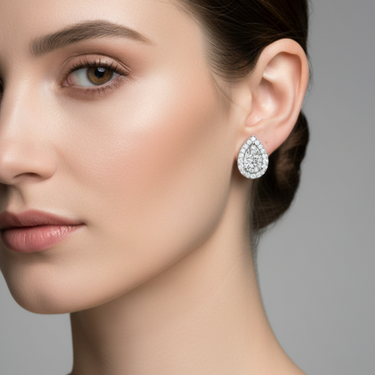 Female model wearing small pear-shaped diamond halo stud earrings in white gold