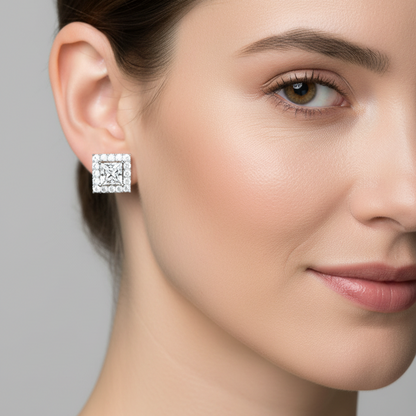 Female model wearing small princess-cut diamond halo stud earrings in white gold