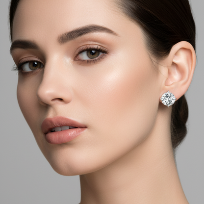 Female model wearing small round brilliant diamond three-prong martini solitaire stud earrings in white gold