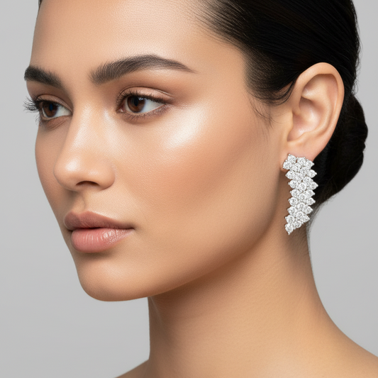Female model wearing small white gold elongated diamond cluster drop earrings