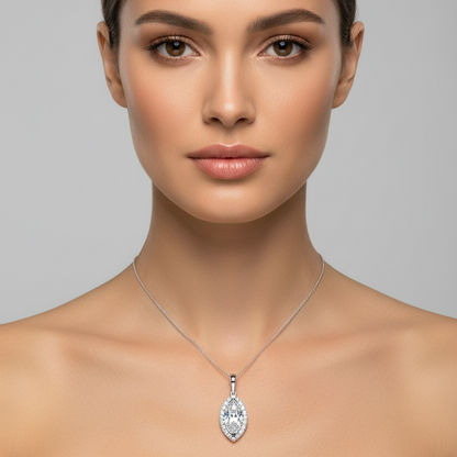 Female model wearing small white gold marquise-cut diamond halo pendant necklace with vertical marquise center stone surrounded by continuous round brilliant diamond halo border on fine white gold chain