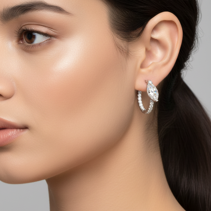 Female model wearing small white gold marquise diamond pavé huggie hoop earrings