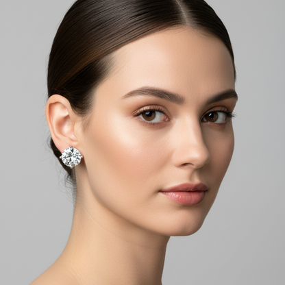 Female model wearing small white gold round brilliant diamond solitaire martini stud earrings with three slim ball-tipped claw prongs in classic open triangular martini setting — one prong at top center and two at bottom left and right — giving the diamonds a floating airy appearance against the earlobe