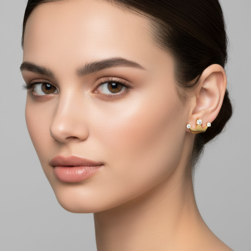 Female model wearing small yellow gold crown diamond stud earrings