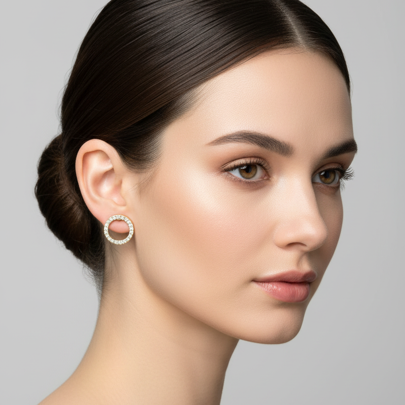 Female model wearing small yellow gold open circle diamond halo stud earrings with full pavé diamond ring frame and open center