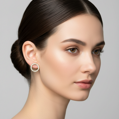 Female model wearing small yellow gold open circle diamond halo stud earrings with full pavé diamond ring frame and open center