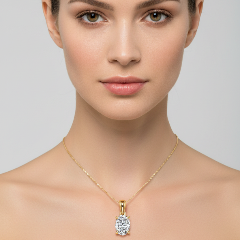 Female model wearing small yellow gold oval-cut diamond solitaire pendant necklace