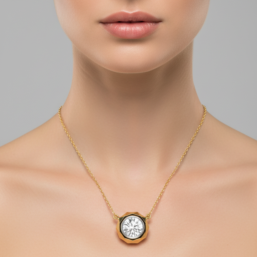 Female model wearing small yellow gold round brilliant diamond solitaire pendant with faceted geometric bezel