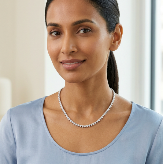 Female model wearing the necklace at a very petite scale, styled with powder-blue silk