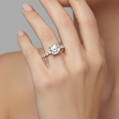 Female model wearing two-tone yellow and white gold cushion-cut diamond engagement ring with large graduating shoulder diamonds
