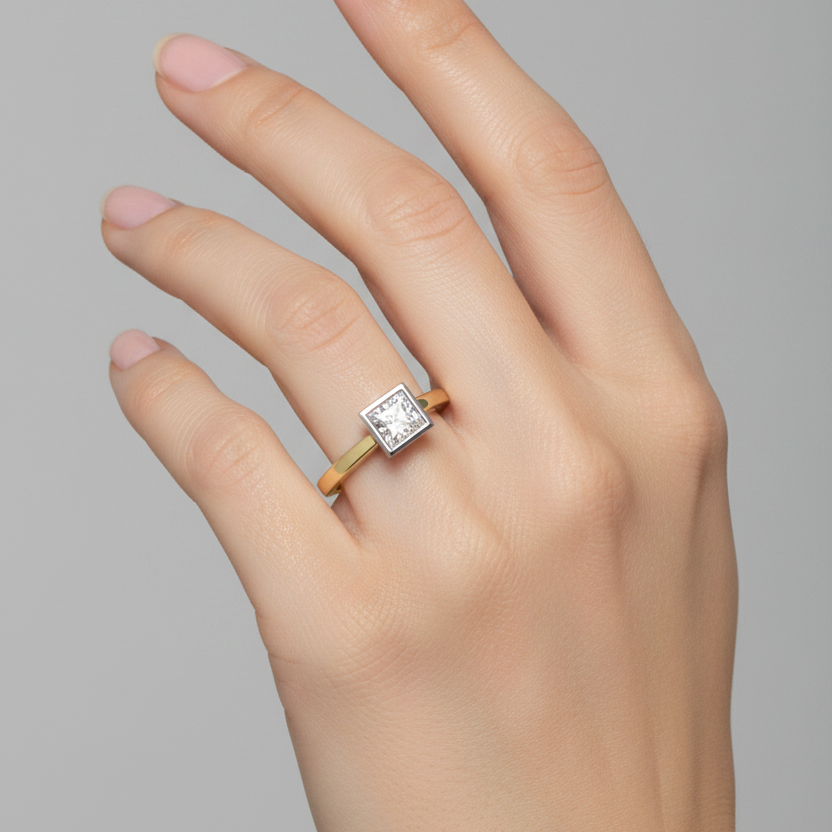 Female model wearing two-tone yellow gold and white gold princess-cut diamond solitaire ring with square box channel setting