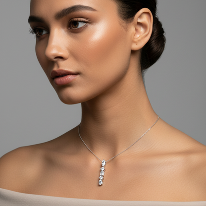 Female model wearing very small petite white gold mixed-cut five-stone linear drop pendant from 3/4 angle showing three-dimensional depth of marquise, round brilliant, emerald-cut, round brilliant and oval diamonds stacked vertically on ultra-fine white gold chain