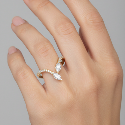 Female model wearing very small petite yellow gold two-stone toi-et-moi V-shaped bypass ring with two crossing marquise diamonds and micro-pavé V band