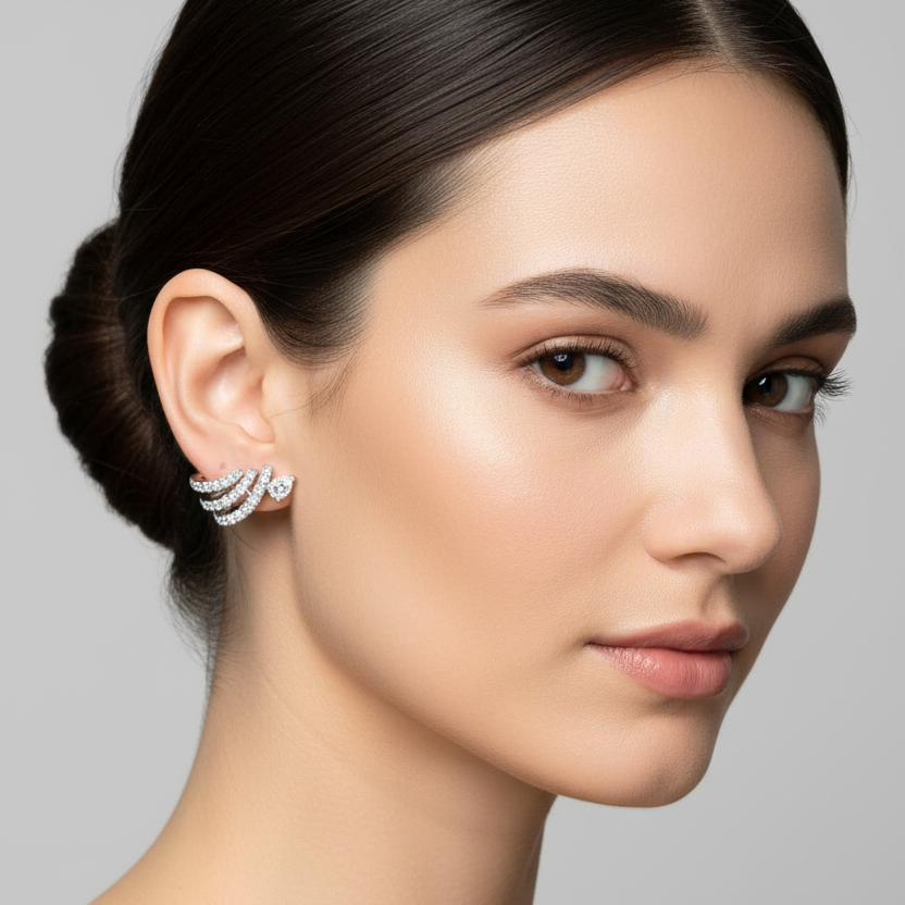 Female model wearing very small white gold diamond fan wing stud earrings with three graduated pavé arcs and center diamond