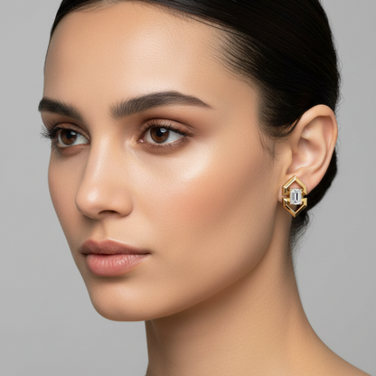 Female model wearing very small yellow gold Art Deco geometric four-pointed star compass-rose open-frame emerald-cut diamond stud earrings with four thick beveled chamfered yellow gold arms extending diagonally outward with stepped waist notch cutouts on each side holding a large emerald-cut diamond in four corner ball-tipped prongs at the center the three-dimensional beveled arms catching light dramatically against the earlobe