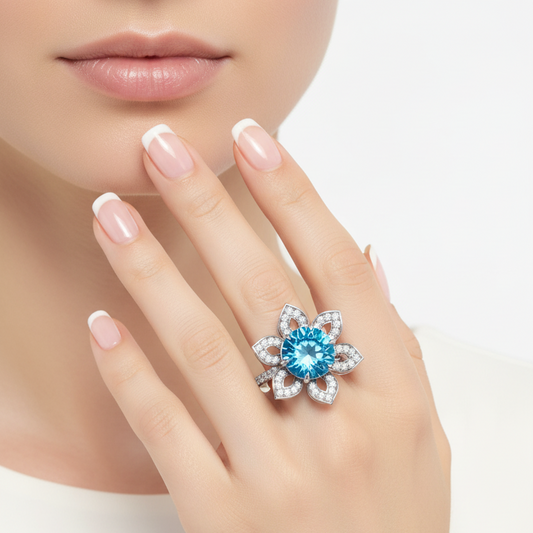Female model wearing white gold blue topaz and diamond floral ring