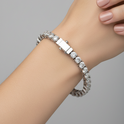Female model wearing white gold large diamond tennis bracelet with four-prong settings and push-button box clasp