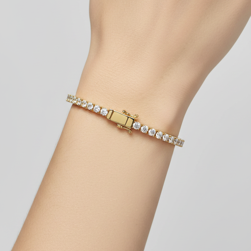 Female model wearing yellow gold classic diamond tennis bracelet with four-prong settings