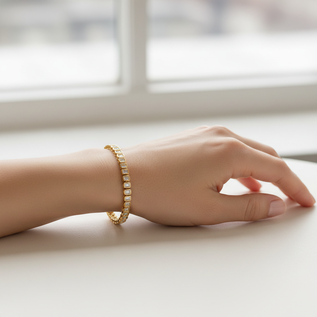 Female model wearing yellow gold emerald-cut diamond tennis bracelet