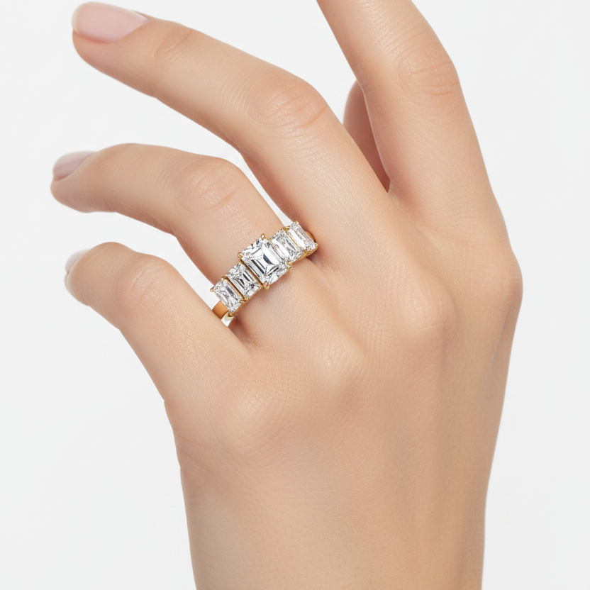 Female model wearing yellow gold five-stone graduating radiant-cut diamond engagement ring